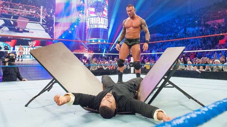 Randy Orton smashing someone through a table
