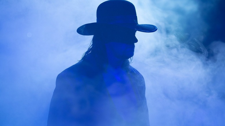 The Undertaker walking through a blue mist