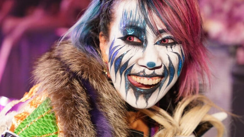 Asuka poses on stage, in her full makeup, before a match on WWE TV.