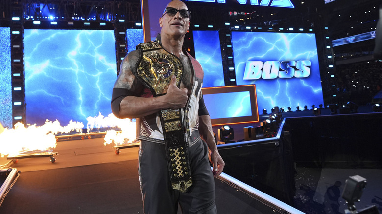 The Rock walks down the ramp with title belt on his shoulder at WrestleMania 40