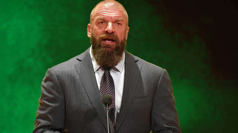 Paul "Triple H" Levesque standing at a podium