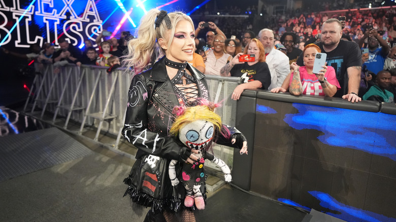 Alexa Bliss, accompanied by her companion Lily, makes her way to the ring.