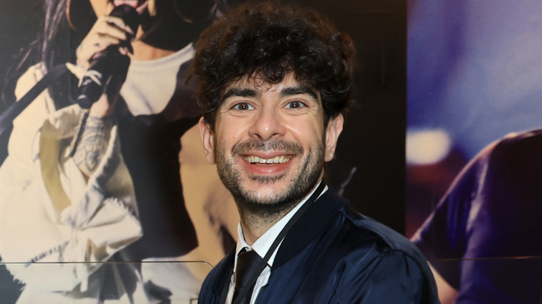 Tony Khan smiling in a suit