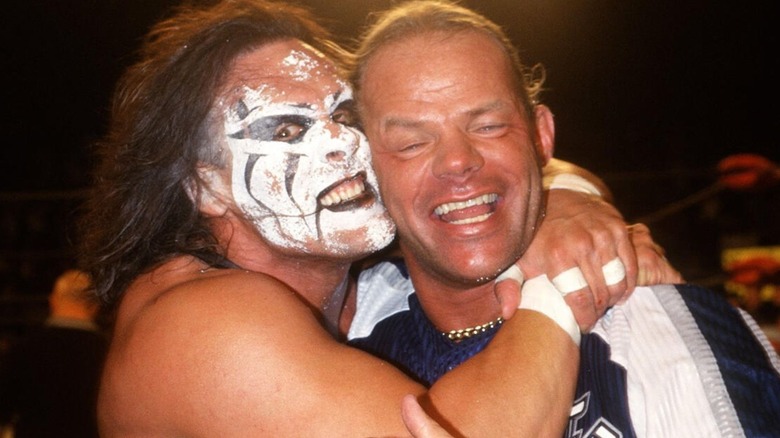 Sting is seen hugging Lex Luger backstage, with his face paint all over his face, after a match.