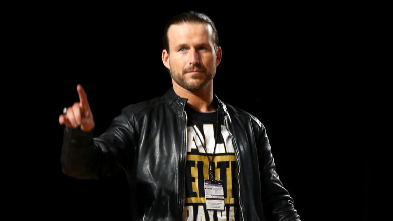 Adam Cole, gesturing for fans to wait a bit longer