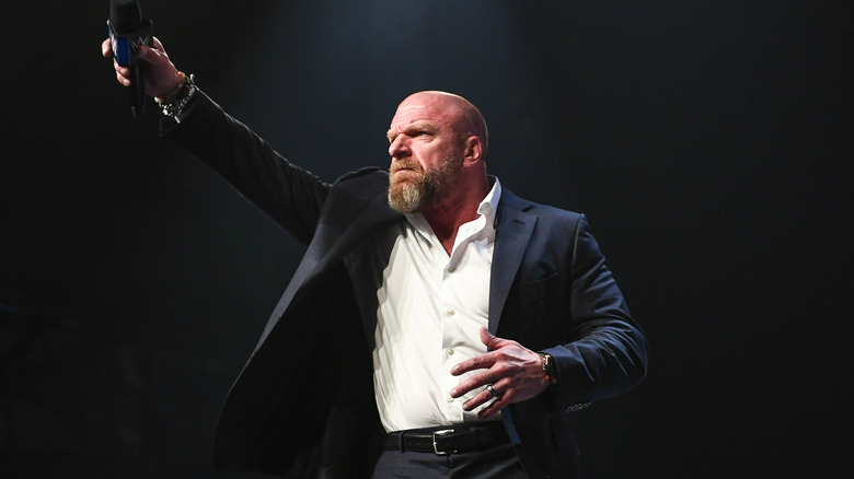 Paul "Triple H" Levesque holding microphone in the air