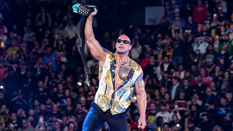 The Rock holds the People's Championship high in the ring