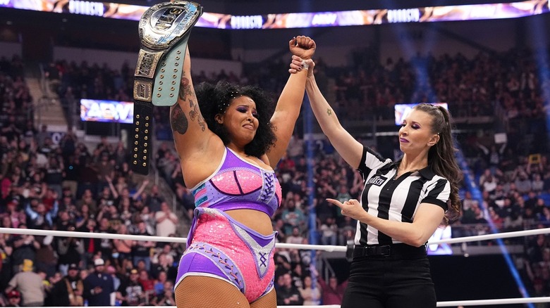 Willow Nightingale celebrates with the TBS Championship as referee Aubrey Edwards raises her arm