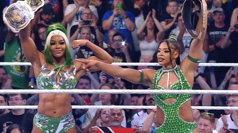 Jade Cargill and Bianca Belair raise their WWE Women's Tag Team Championships.