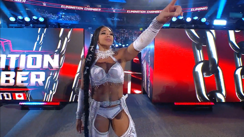 Bianca Belair points to the WrestleMania sign