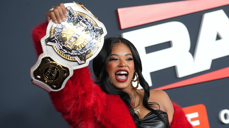 Bianca Belair holding up the WWE Women's Tag Team Championship belt