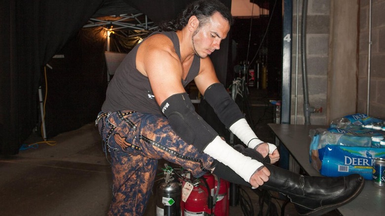 Matt Hardy laces hits boots backstage before a match in WWE.