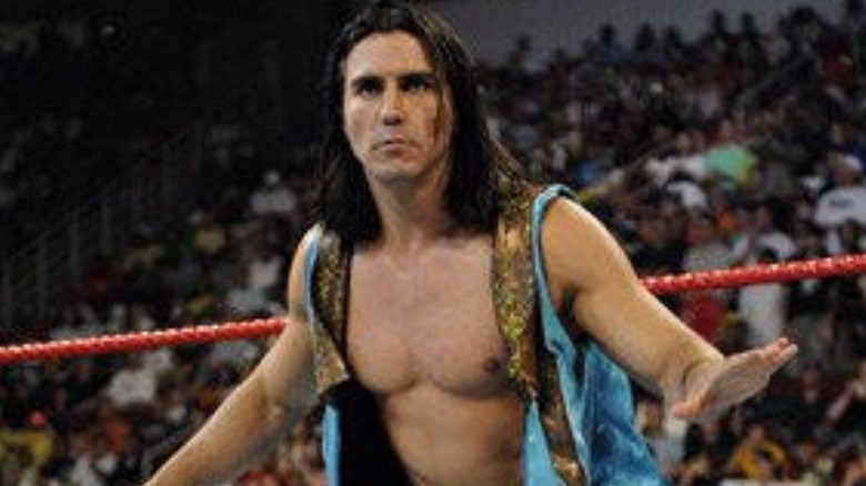 Paul London stands in the ring, hands outstretched, before a match in WWE.