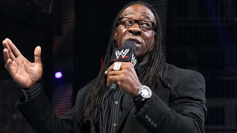 Booker T wearing a suit and holding a mic