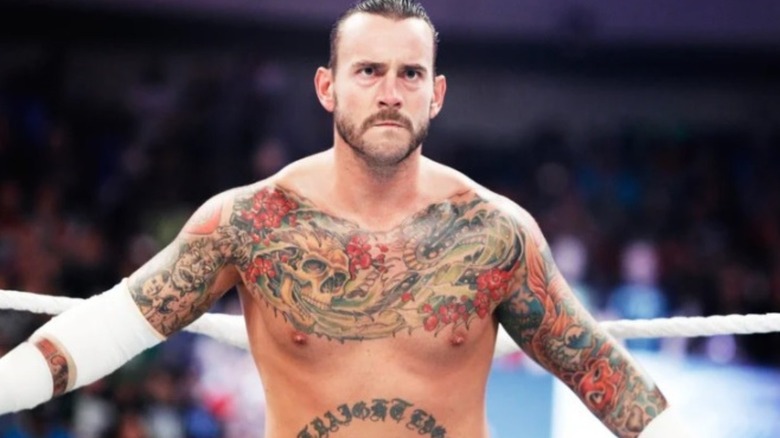 CM Punk stands in the corner of the ring before a match in WWE.