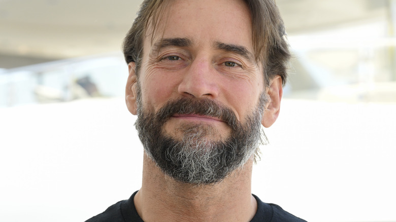 CM Punk stands in front of boat