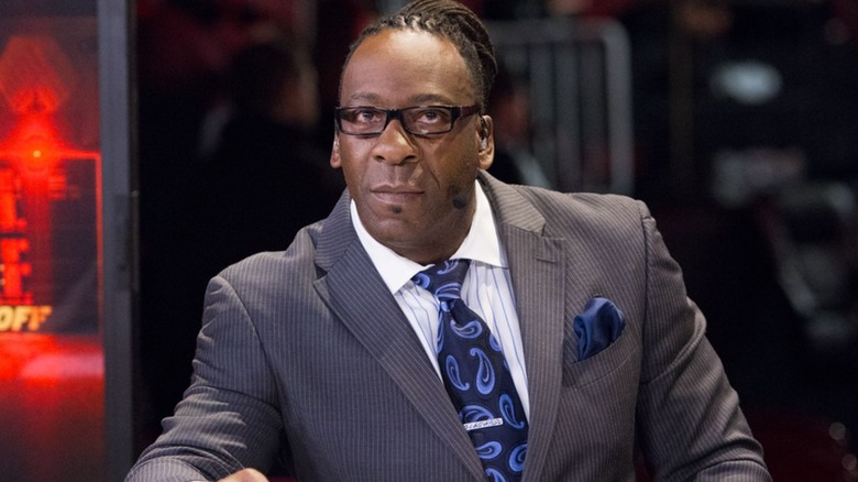 WWE Hall of Famer Booker T sits behind the desk during a pre-show before a premium live event.