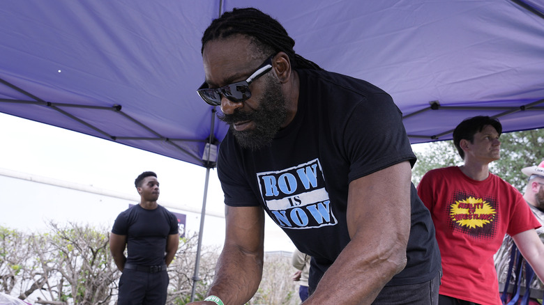 Booker T leaning down to sign an autograph