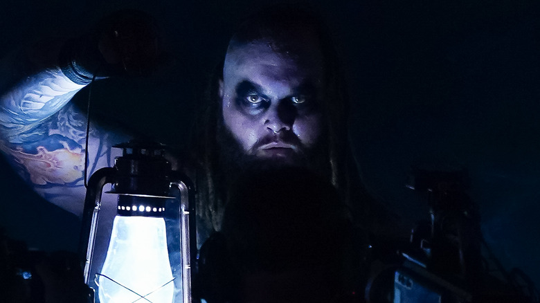 Bray Wyatt holds a lantern in the darkness