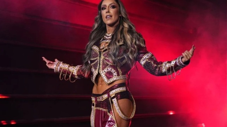 Britt Baker poses on the stage in her ring gear before a match on AEW programming.