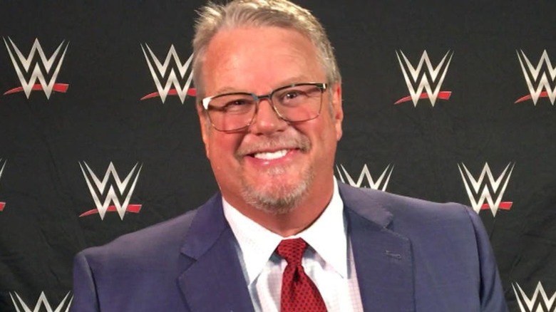 Bruce Prichard in front of a bunch of WWE logos