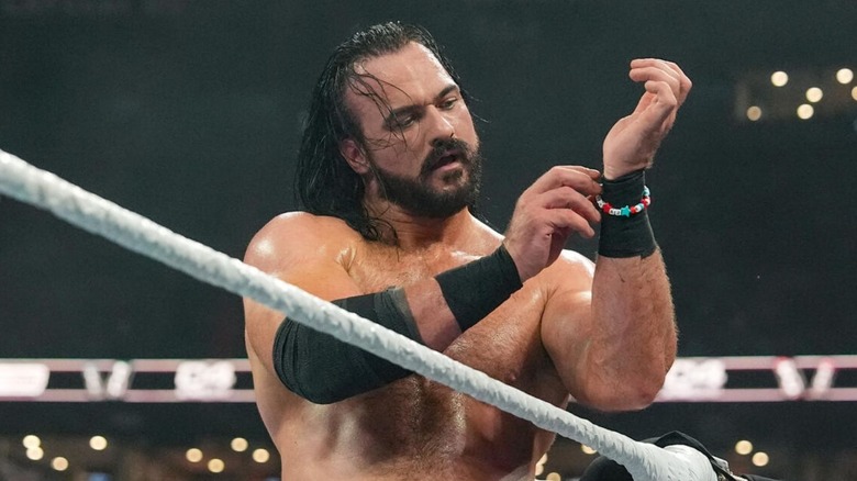 Drew McIntyre se pone una pulsera de la amistad con cuentas que lleva los nombres de la esposa y el perro de CM Punk en la esquina del ring durante su combate en WWE SummerSlam.