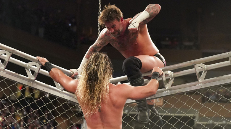 CM Punk about to punch Seth Rollins inside a steel cage