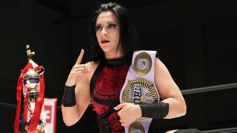 Stephanie Vaquer with the NJPW Strong Women's Championship posing beside a trophy