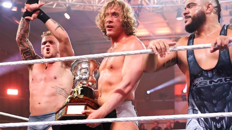 Charlie Dempsey holds up his newly won Heritage Cup flanked by the No Quarter Catch Crew in the ring on "WWE NXT."