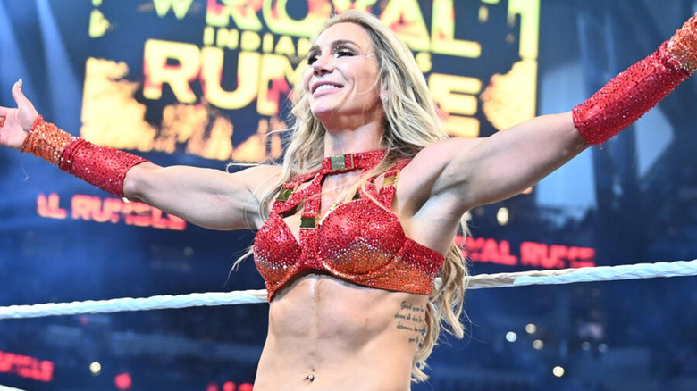 Charlotte Flair grins and spreads her arms after her Royal Rumble victory.