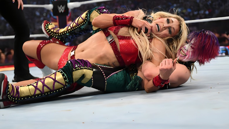 Asuka with Charlotte Flair in a hold