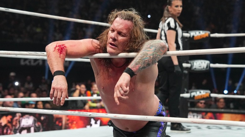 Chris Jericho lays across the ropes exhausted