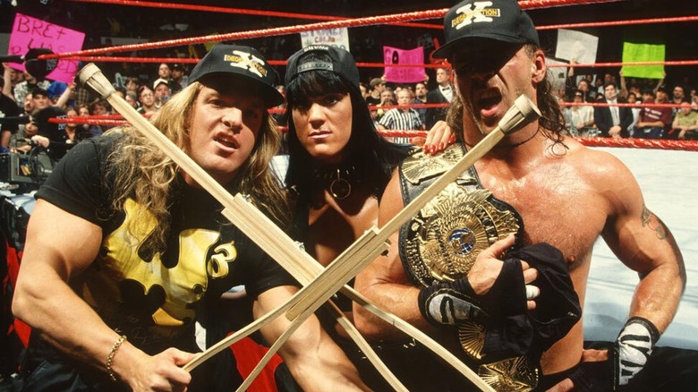 Triple H, Chyna, and Shawn Michaels pose ringside