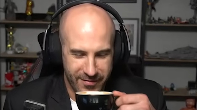 Cesaro wearing headphone and about to take a sip of coffee