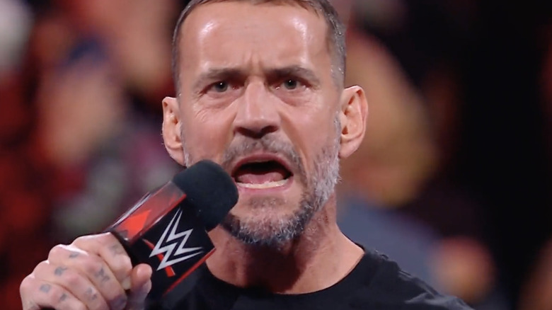 CM Punk with a WWE microphone in a WWE ring in 2023