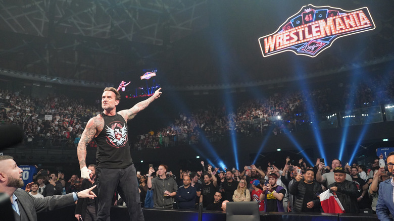 CM Punk points at the WrestleMania sign