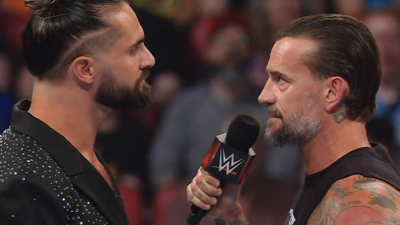 Seth Rollins and CM Punk square off in the ring.