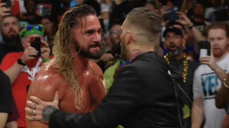 Corey Graves attempts to hold an irate Seth Rollins back.