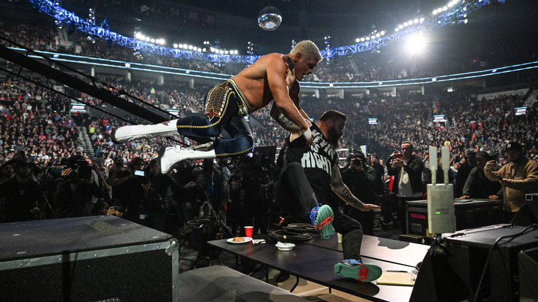 Cody Rhodes and Kevin Owens crashing through tables