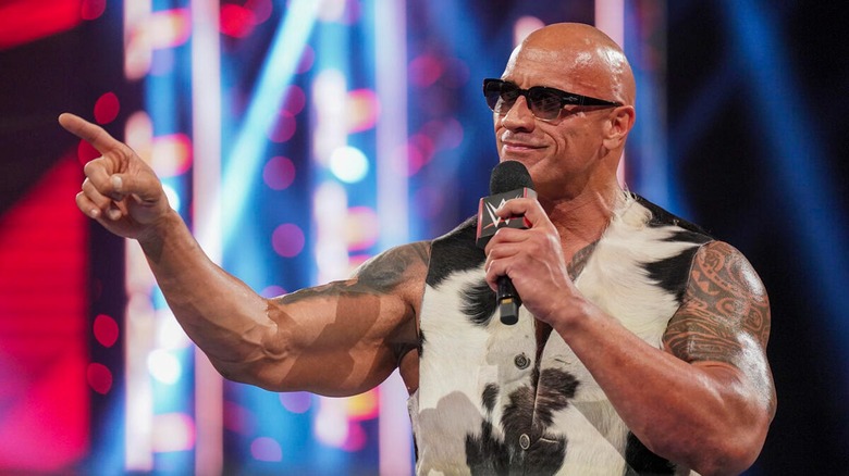 The Rock holds WWE microphone and points his finger
