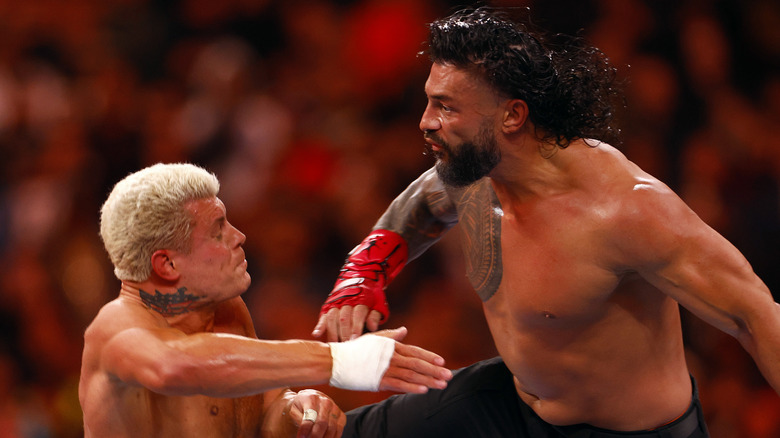 Roman Reigns punching Cody Rhodes