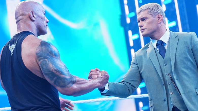 Dwayne "The Rock" Johnson and Cody Rhodes shake hands.