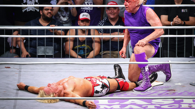 Ric Flair kneels above Jeff Jarrett