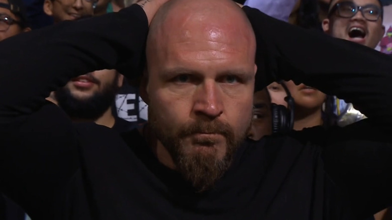 Jon Moxley stares forward, blank and dejected, as he rests his hands on his head.