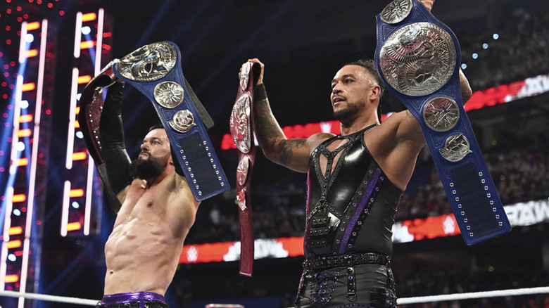 Finn Balor and Damian Priest holding up the WWE Tag Team Championships