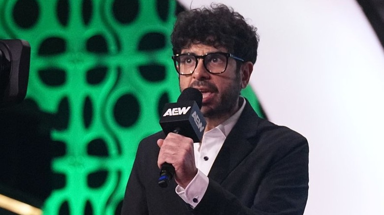 Tony Khan speaking in glasses