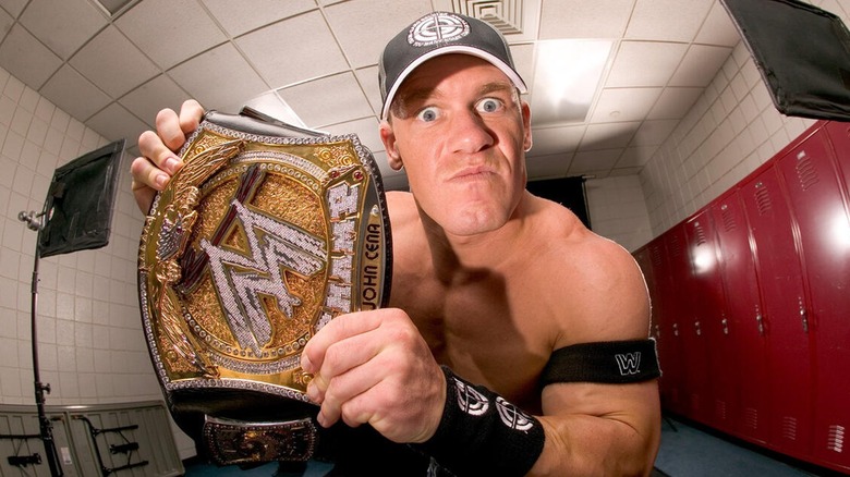 John Cena posing with the title