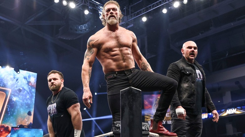 Cash Wheeler, Adam Copeland, and Dax Harwood standing on the ring ropes