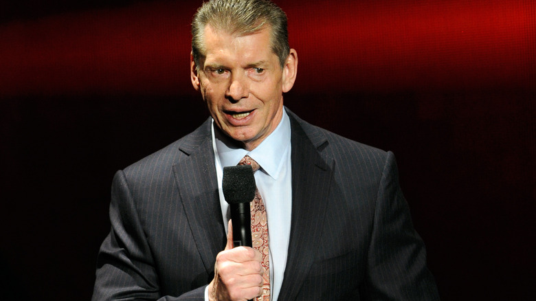 Vince McMahon speaking into microphone