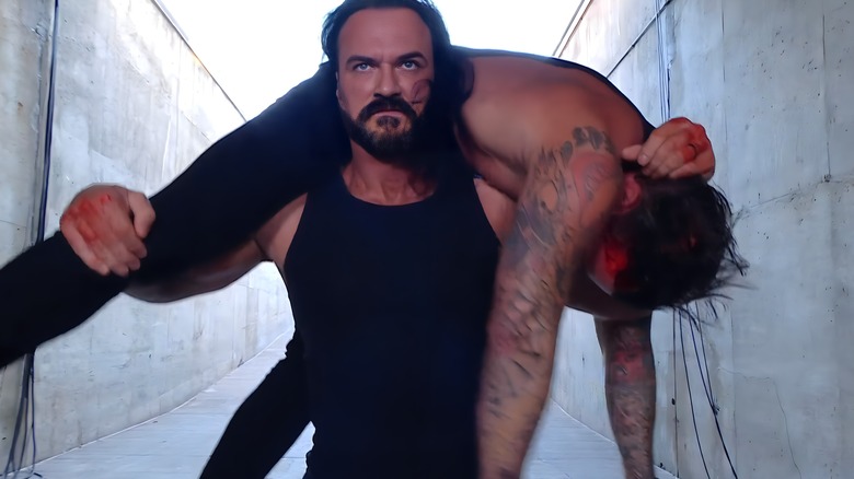 Drew McIntyre carries a bloodied CM Punk on his shoulders